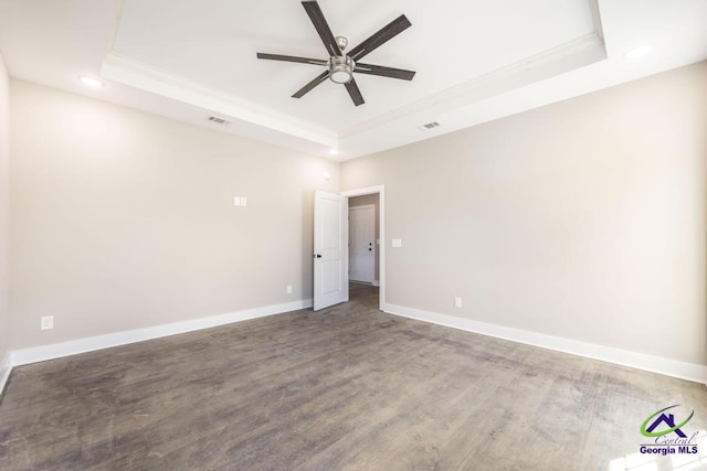 spare room featuring a raised ceiling, wood-type flooring, ornamental molding, and ceiling fan