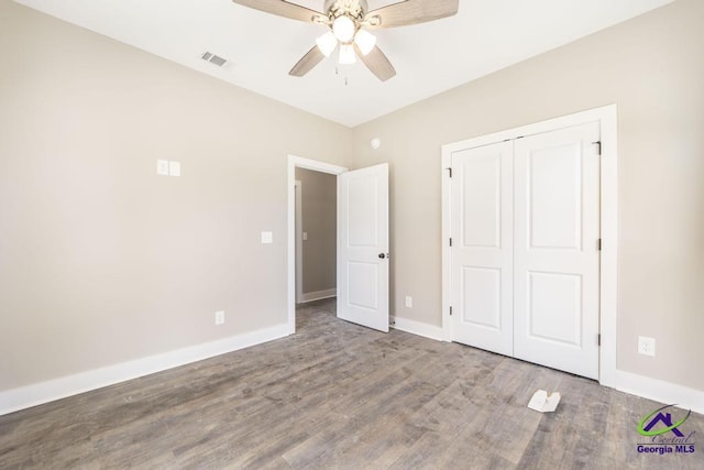 unfurnished bedroom featuring hardwood / wood-style floors, a closet, and ceiling fan