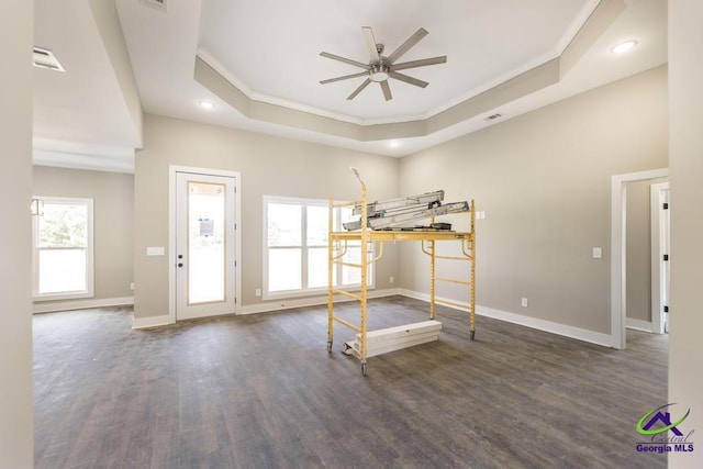 unfurnished bedroom featuring dark wood-type flooring, ornamental molding, and a tray ceiling