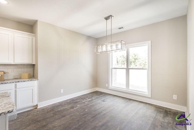 unfurnished dining area featuring dark wood-type flooring