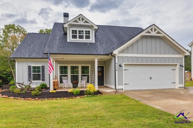 view of front facade featuring a garage, covered porch, and a front yard