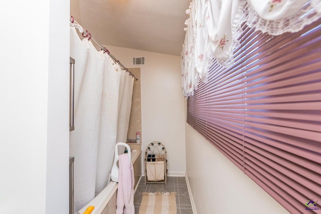 bathroom with tile patterned floors and vaulted ceiling