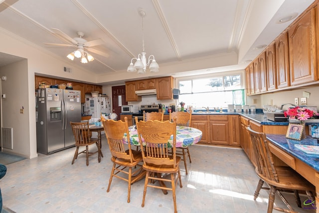 kitchen featuring ceiling fan with notable chandelier, stainless steel appliances, crown molding, sink, and pendant lighting