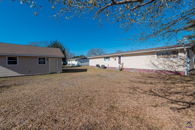 rear view of property with a yard and an outdoor structure