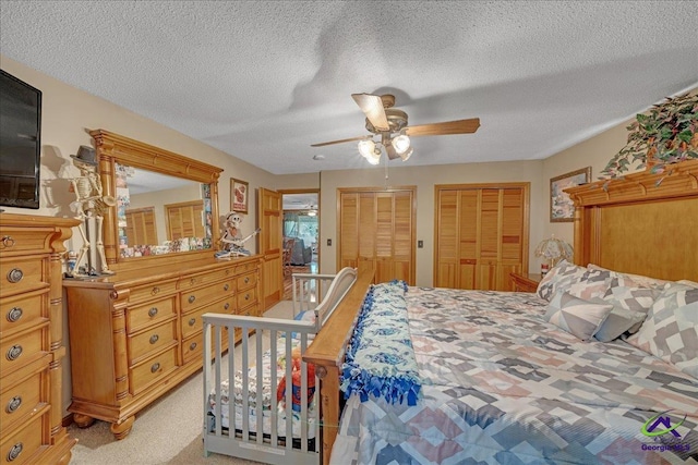 carpeted bedroom featuring a textured ceiling and ceiling fan