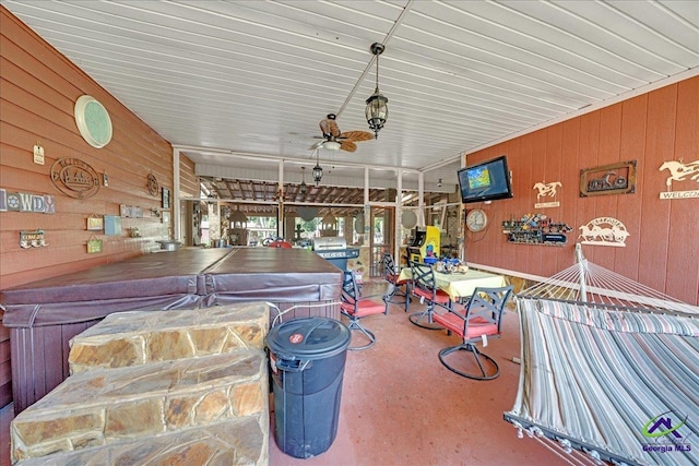 miscellaneous room with ceiling fan and wood walls