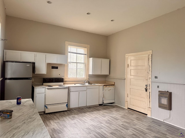 kitchen featuring heating unit, white cabinets, white appliances, and light wood-type flooring