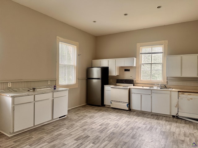 kitchen featuring white cabinetry, sink, light hardwood / wood-style floors, and white appliances