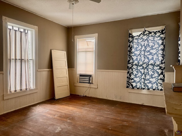 unfurnished bedroom featuring hardwood / wood-style floors, ceiling fan, cooling unit, and a textured ceiling