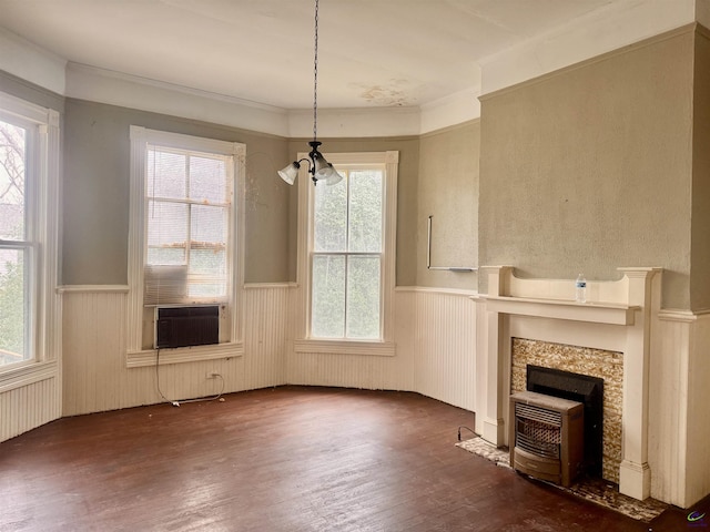 unfurnished living room featuring a wealth of natural light, dark hardwood / wood-style flooring, and an inviting chandelier