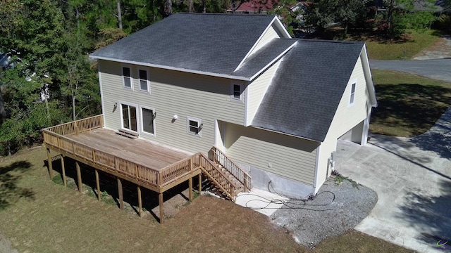 rear view of house with a wooden deck and a garage