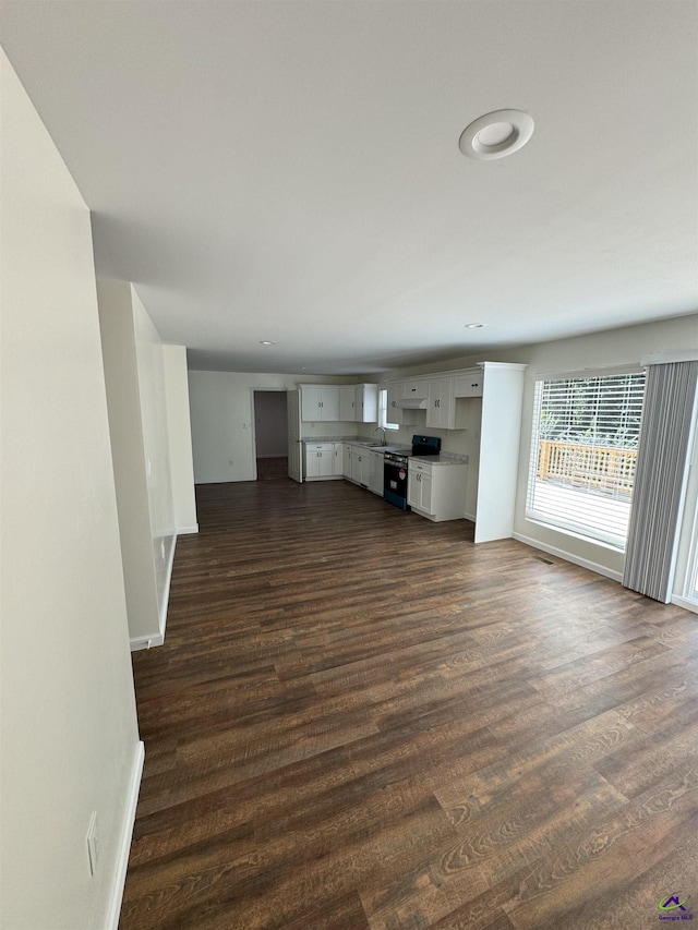 unfurnished living room with dark hardwood / wood-style floors and sink