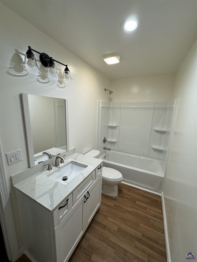 full bathroom with hardwood / wood-style flooring, vanity, toilet, and washtub / shower combination