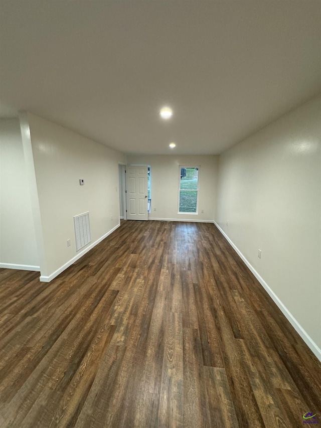 unfurnished living room with dark wood-type flooring