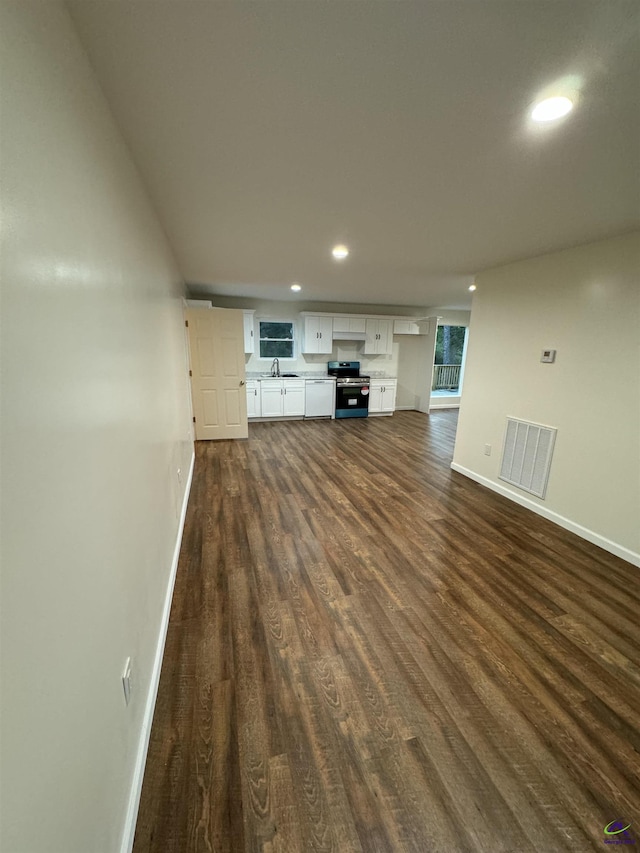 unfurnished living room featuring dark hardwood / wood-style flooring and sink