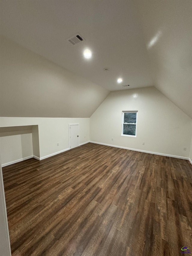 additional living space featuring dark hardwood / wood-style floors and lofted ceiling