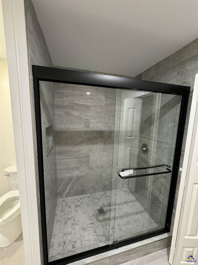 bathroom with tile patterned floors, toilet, and walk in shower