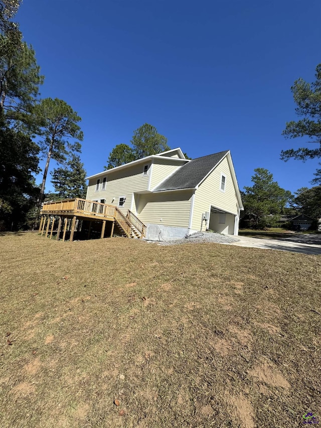 view of front of house with a garage, a front yard, and a deck