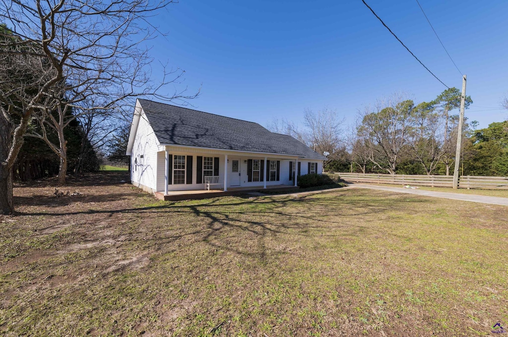 view of front of house with covered porch and a front lawn