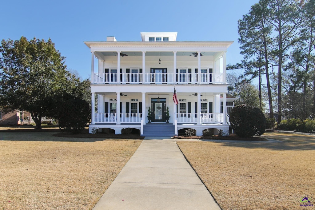 view of front of home featuring covered porch, french doors, and a front yard