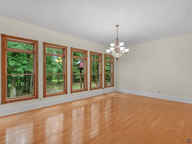 unfurnished room featuring light hardwood / wood-style floors and a notable chandelier