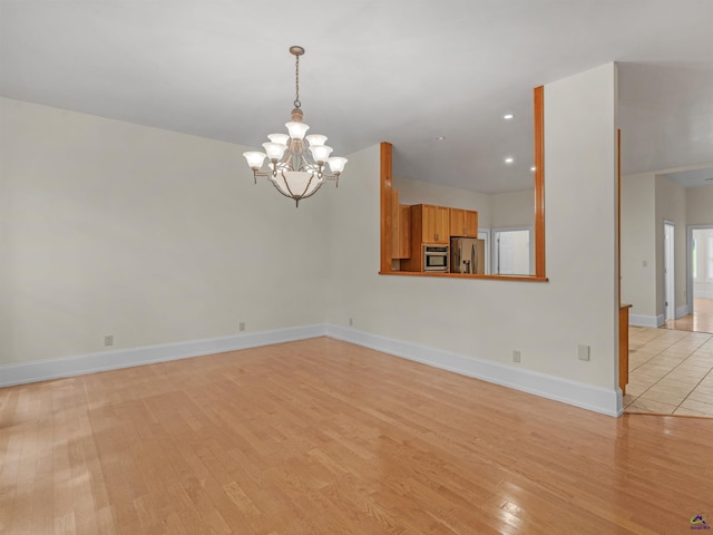 empty room featuring light hardwood / wood-style floors and an inviting chandelier