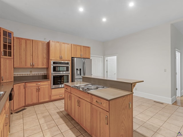 kitchen with light tile patterned floors, a center island, and stainless steel appliances