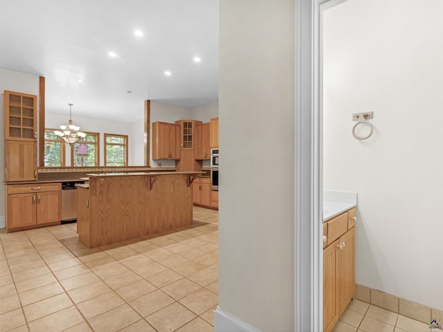 kitchen featuring a breakfast bar, stainless steel appliances, pendant lighting, a chandelier, and light tile patterned flooring