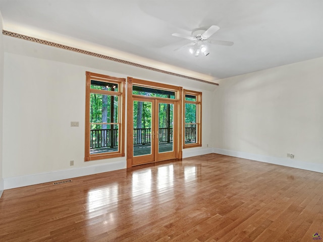 empty room featuring ceiling fan, french doors, and light hardwood / wood-style flooring