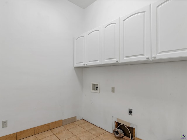 laundry area with electric dryer hookup, hookup for a washing machine, light tile patterned floors, and cabinets