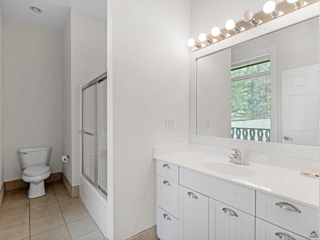 full bathroom featuring shower / bath combination with glass door, tile patterned floors, vanity, and toilet