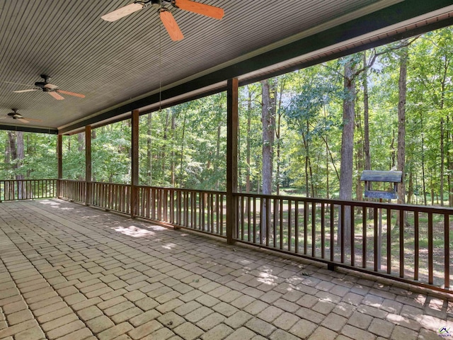 unfurnished sunroom featuring ceiling fan