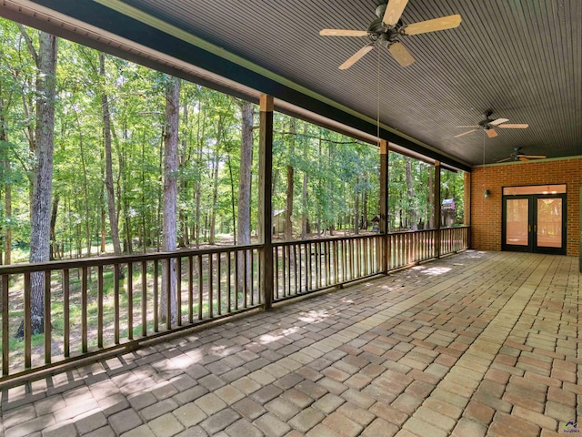 unfurnished sunroom featuring french doors, a wealth of natural light, and ceiling fan