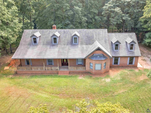 new england style home featuring a front yard and covered porch