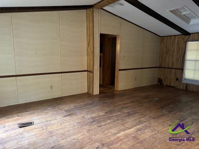 unfurnished room with dark hardwood / wood-style flooring and lofted ceiling with beams