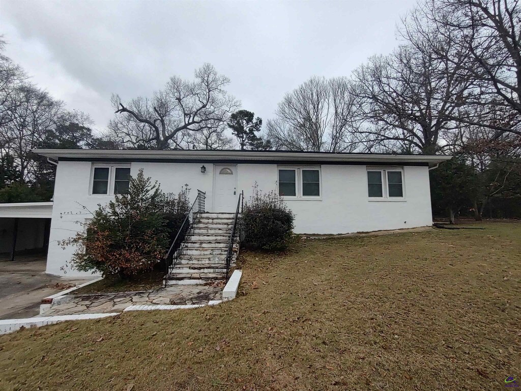 view of front of house with a front lawn and a carport