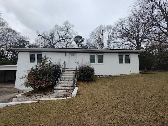 view of front of house with a front lawn and a carport