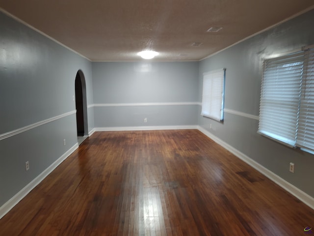 spare room with dark hardwood / wood-style flooring and ornamental molding