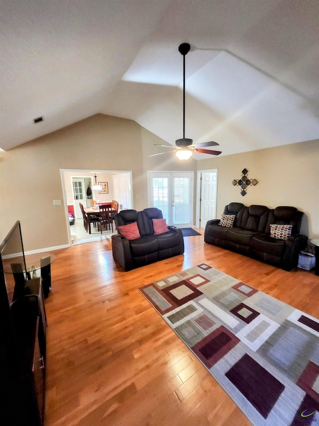 living room featuring ceiling fan, hardwood / wood-style floors, and vaulted ceiling