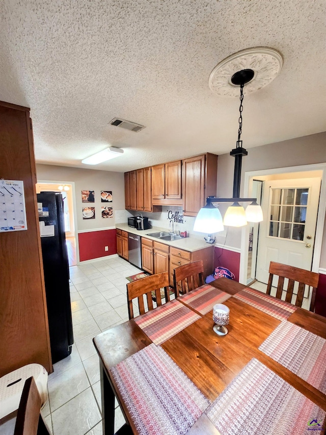 dining area featuring a textured ceiling, light tile patterned floors, and sink