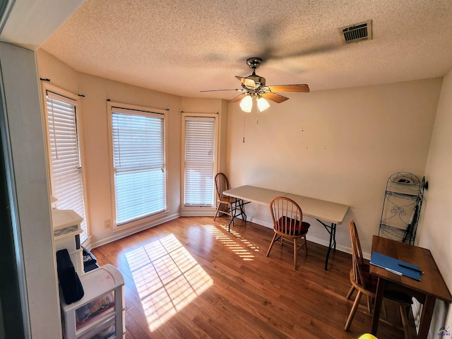 dining space featuring a textured ceiling, hardwood / wood-style flooring, and ceiling fan