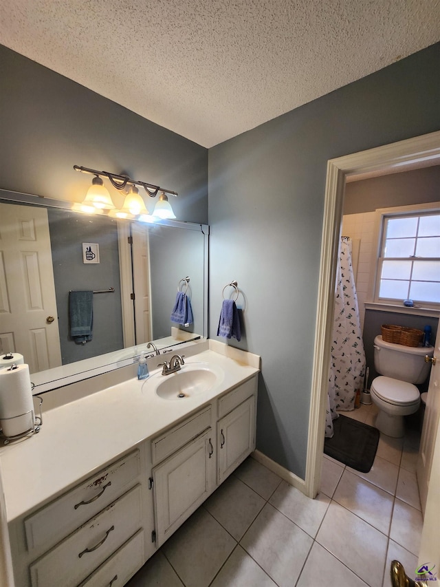 bathroom with tile patterned floors, vanity, a textured ceiling, and toilet