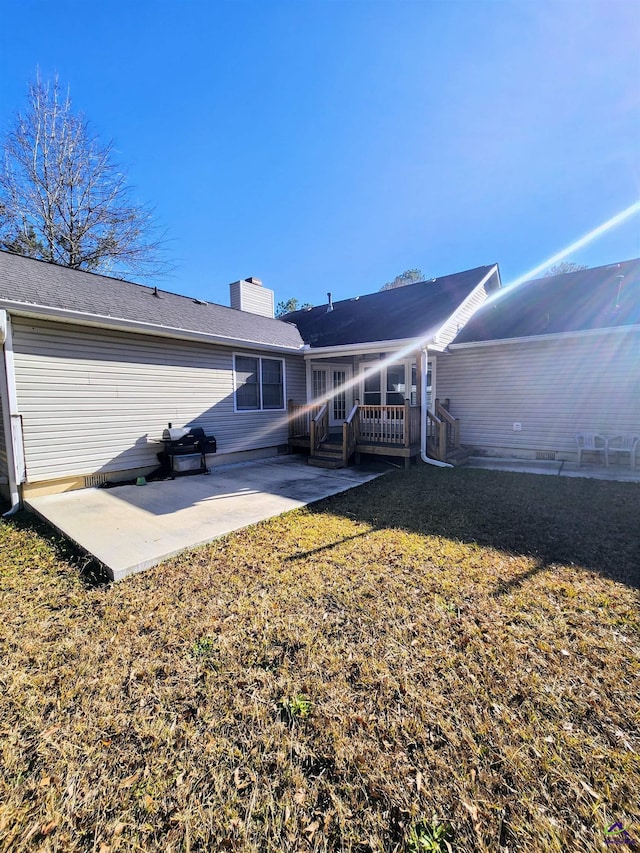 back of house featuring a yard, a patio, and a wooden deck