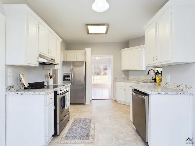 kitchen featuring white cabinetry, sink, light stone countertops, and appliances with stainless steel finishes