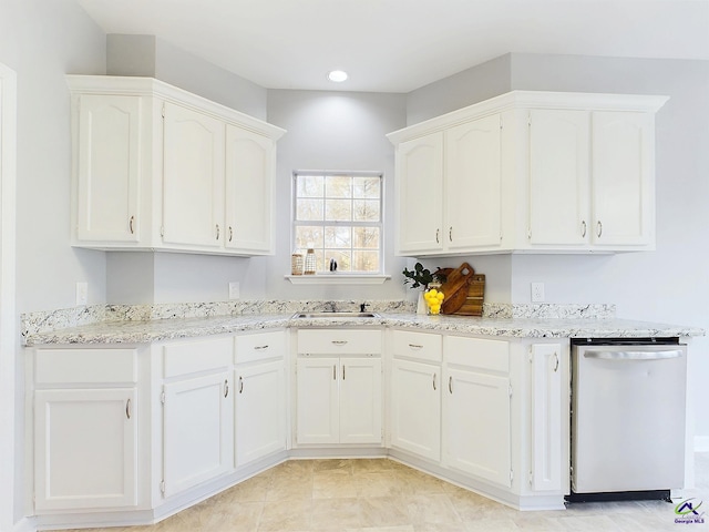 kitchen with dishwasher, white cabinets, light tile patterned flooring, and sink