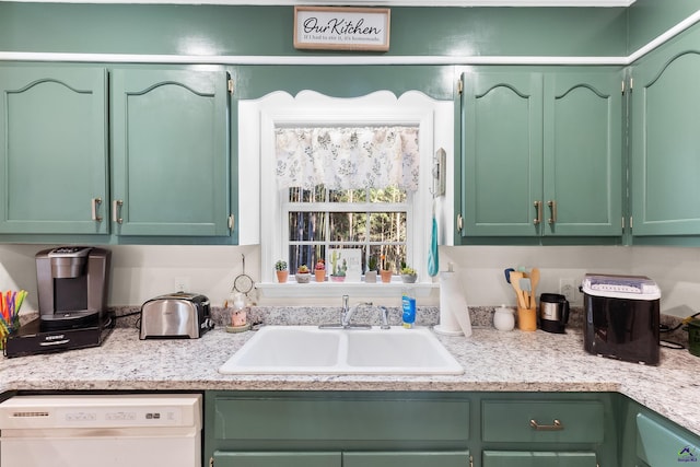 kitchen with dishwashing machine, green cabinetry, and sink