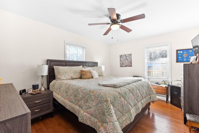 bedroom featuring multiple windows, ceiling fan, and hardwood / wood-style flooring