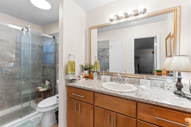 bathroom with vanity, toilet, and a shower with shower door