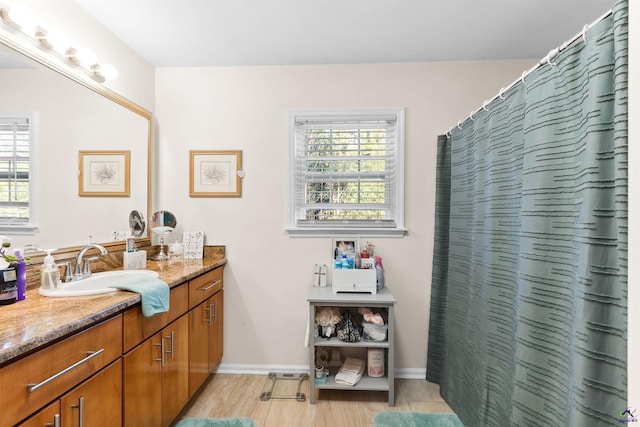 bathroom featuring a shower with shower curtain, hardwood / wood-style floors, and vanity