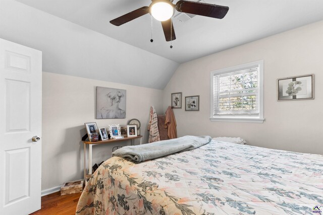 bedroom with hardwood / wood-style flooring, ceiling fan, and vaulted ceiling